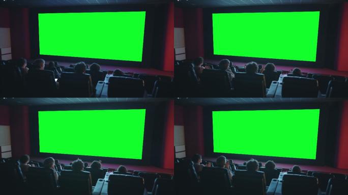 观众在绿色彩色键影院屏幕前拍手