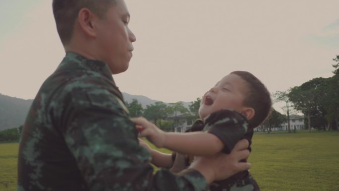 士兵父亲在公园里抱着儿子玩