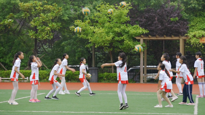 校园操场上孩子们在练排球-体育训练运动