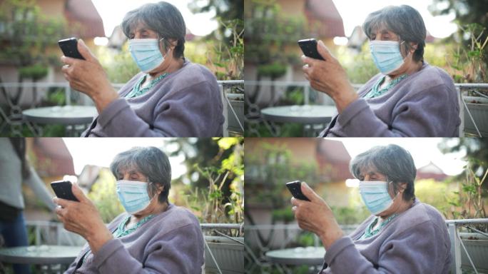 戴面罩的老妇人老年人老人看手机居家
