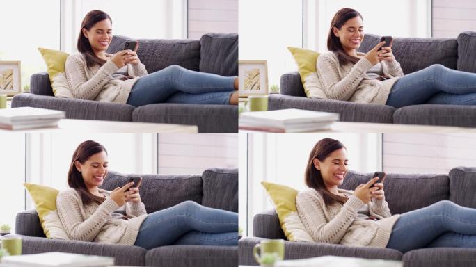 一个迷人的年轻女子在家休息时使用手机