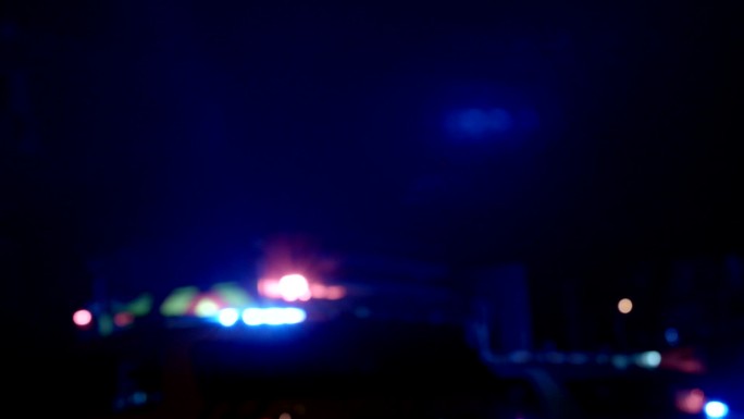 救护车、警察和消防车在夜间模糊了背景灯光