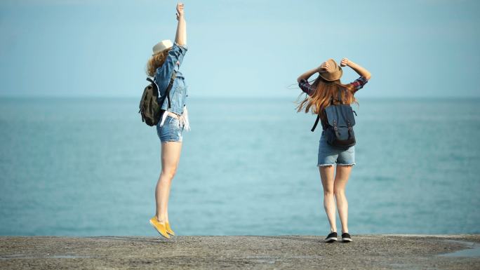 年轻女子在海边嬉戏跳舞。