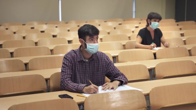戴着口罩的大学生在大学里听课