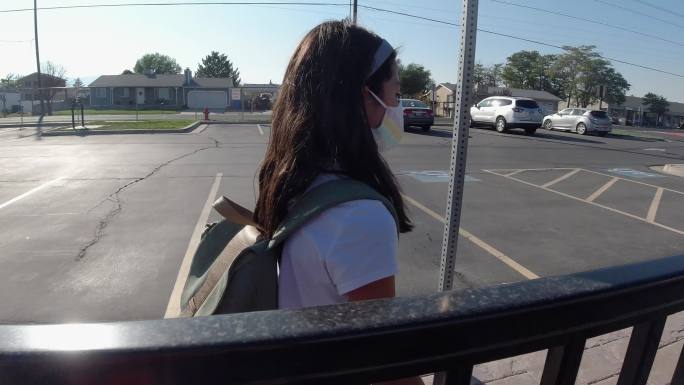 戴着口罩步行上学的年轻女孩