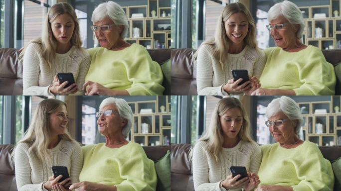 年轻女子和她年老的亲戚在家里一起使用手机