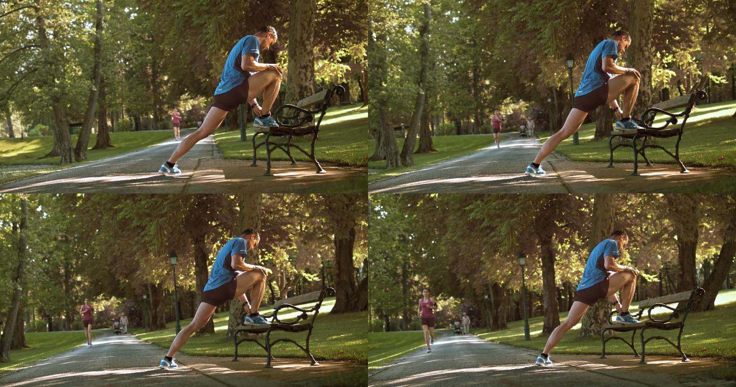 一个男子在公园的长凳上伸腿