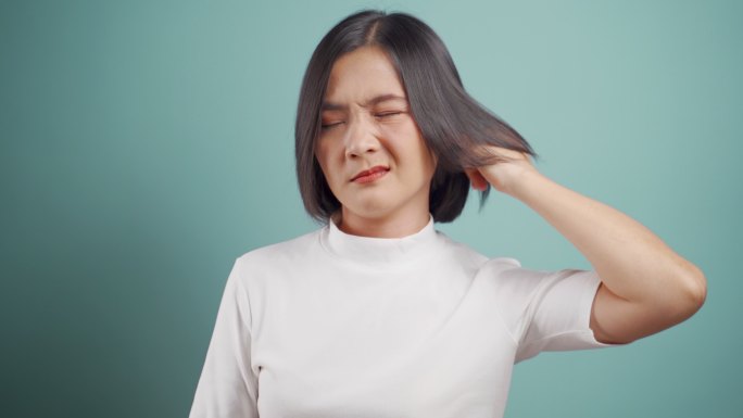 一名亚洲妇女将手指伸进耳朵