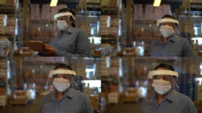 使用数字平板电脑带口罩的女仓库工人