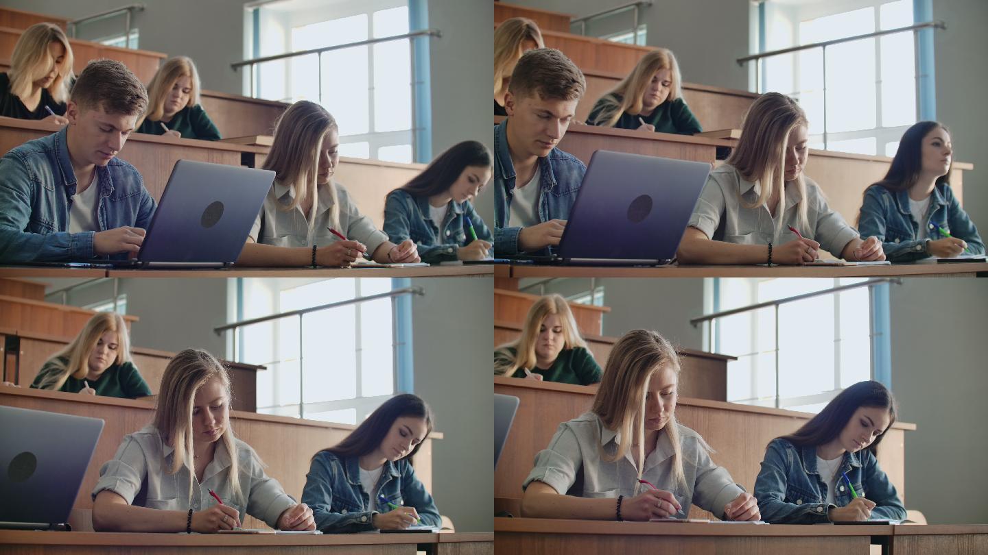一群学生在现代教室里用笔记本电脑一边听讲座