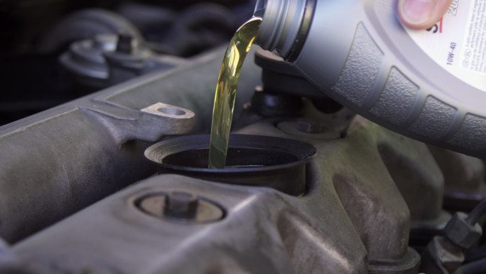汽车修理工正在更换机油