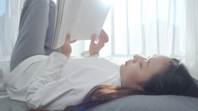 女生悠闲看书、躺着看书