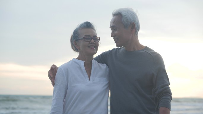 老年夫妇在海滩上相互拥抱
