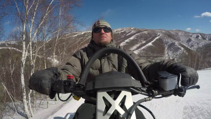 外国游客在滑雪场驾驶摩托雪橇快速速行驶