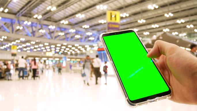 男子在机场使用绿色屏幕手机
