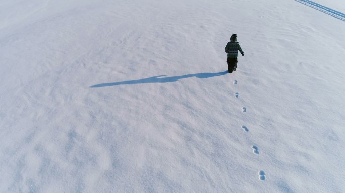 在雪地里奔跑的小男孩