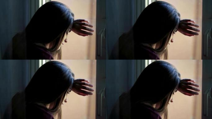 悲伤的女孩在窗边想着一些事情