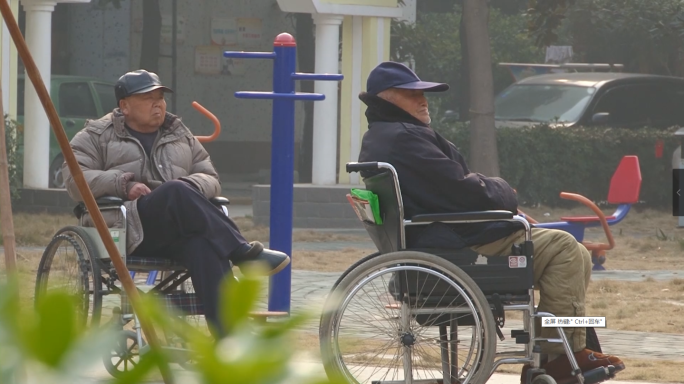 小区广场休闲的人们，坐轮椅的老人
