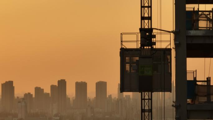 夕阳下航拍建筑工地，城市背景