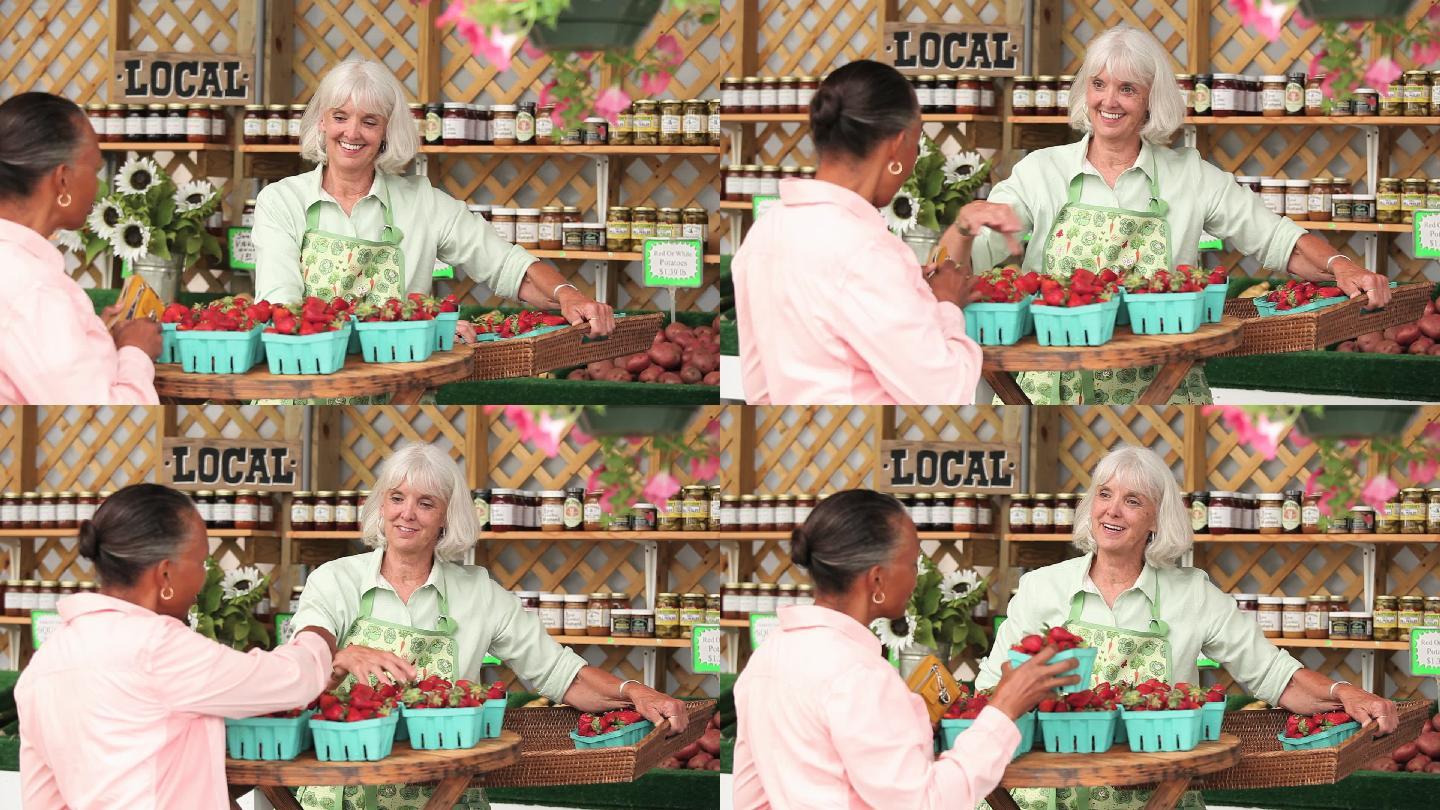 在农贸市场向工人购买一篮新鲜草莓的妇女
