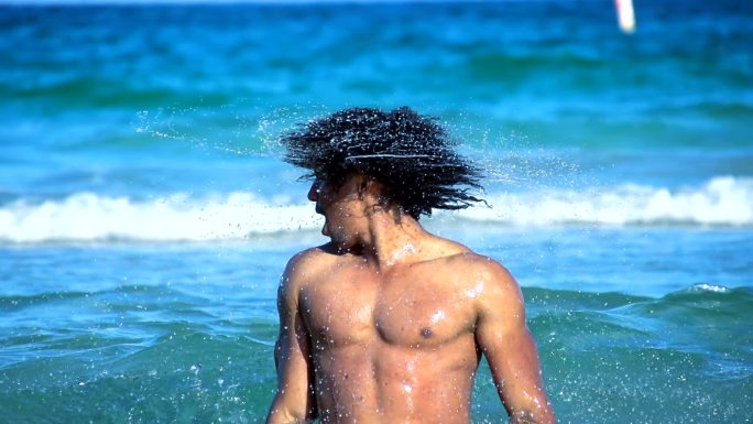 性感男子在水中摇动头发