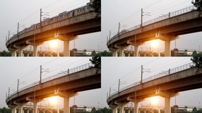 德里地铁列车在日落时分通过大桥