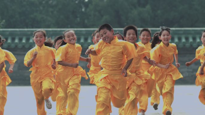 一群穿黄色练功服的孩子在天坛奔跑