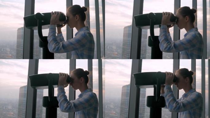 女人透过旅游望远镜观察城市景观