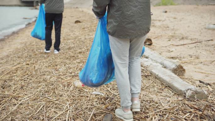 志愿者沿着海岸线收集垃圾