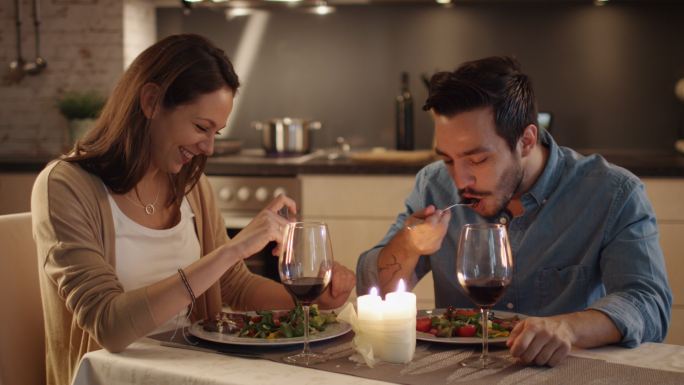 一对夫妇在厨房吃烛光晚餐。