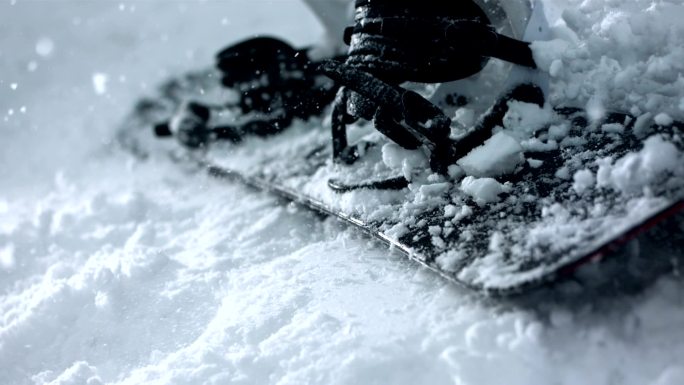 一块滑雪板掉在雪地上的超级慢动作镜头。