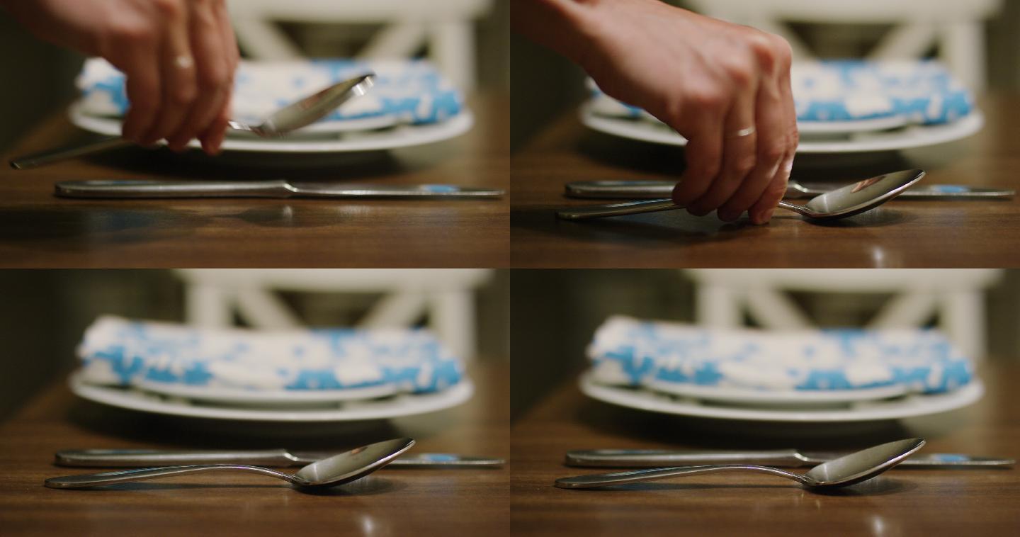 手把勺子放在木桌上的桌刀旁边