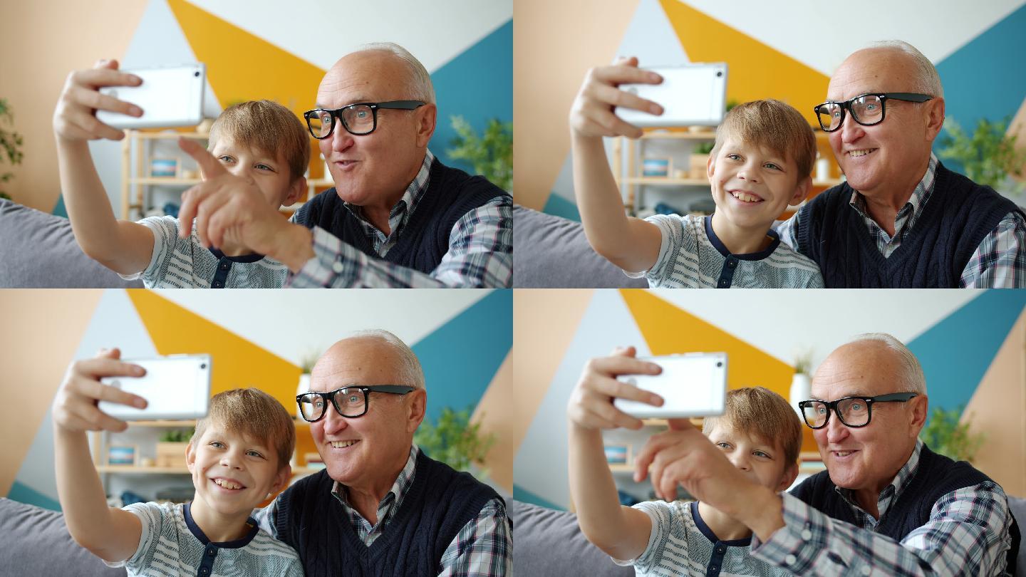 老人和男孩在家自拍用智能手机摆出姿势