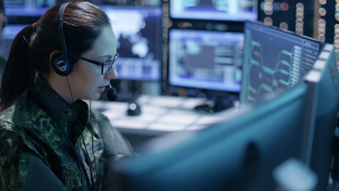 女性军事技术支持专业人员将指令输入电脑