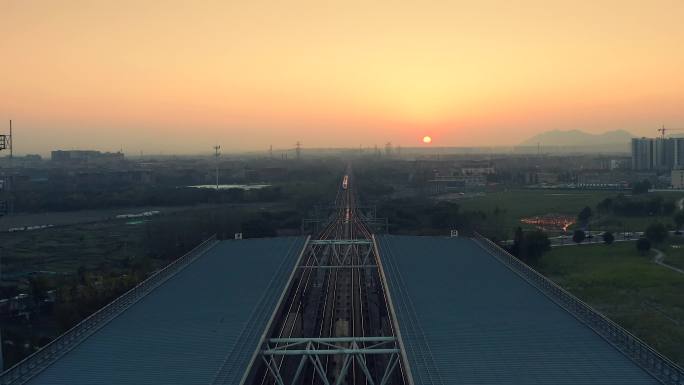 航拍高铁在夕阳下进站出站