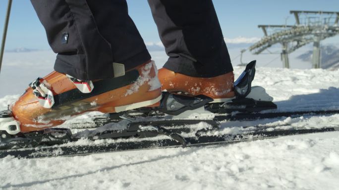 滑雪者用他的滑雪靴踩入滑雪绑定