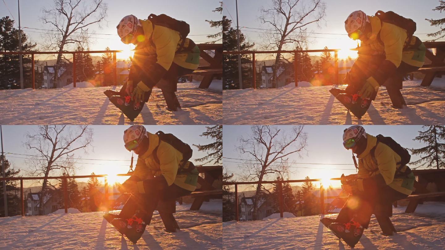 日落时分，坐着穿滑雪靴的男人