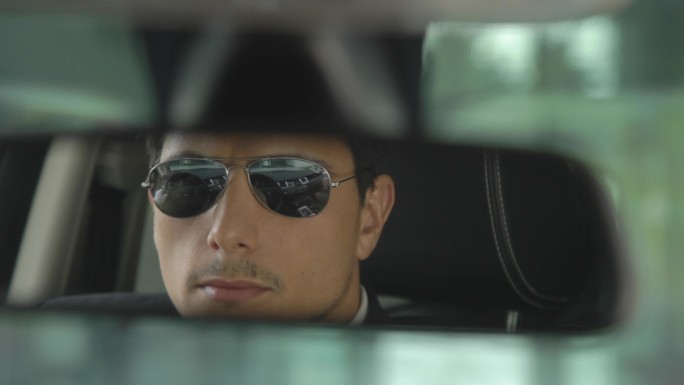出租车司机戴着黑色的太阳镜和白手套