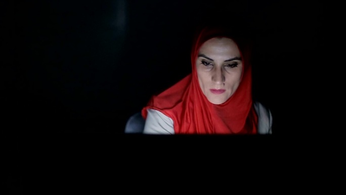 深夜现代阿拉伯妇女在家里用电脑工作