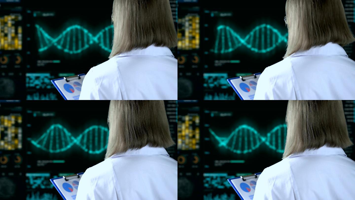 遗传学家在屏幕上观看DNA分析过程