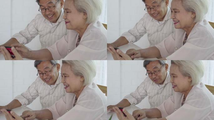 亚洲老年夫妇在家使用智能手机