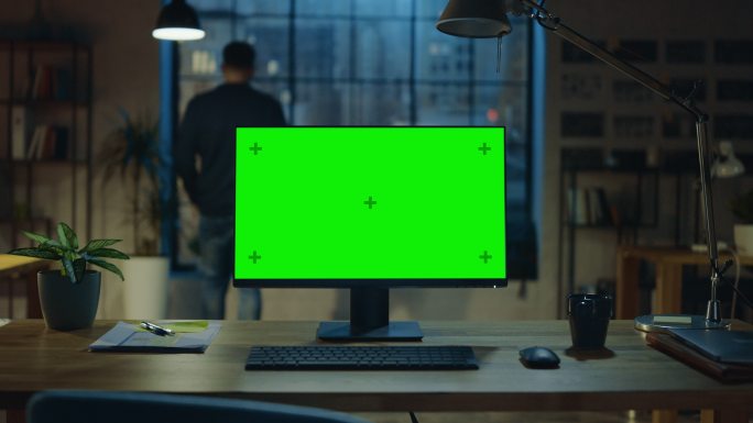 办公桌上放着一台带有模拟绿色屏幕的台式电