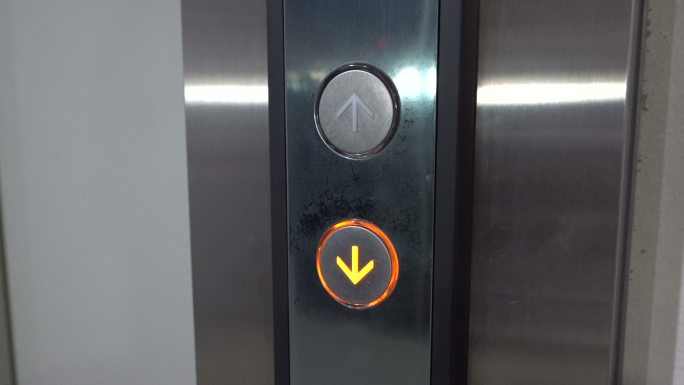 用手指按下电梯下降的按钮