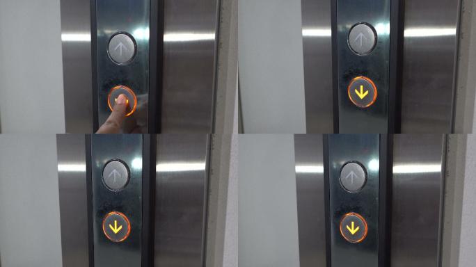 用手指按下电梯下降的按钮
