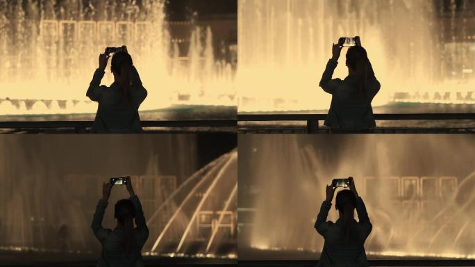 年轻女孩拍摄喷泉的照片和视频