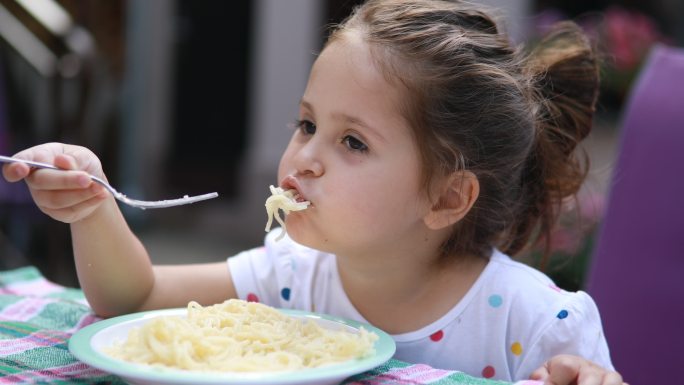 女孩在吃意大利面国外外国婴幼儿宝宝笑脸小