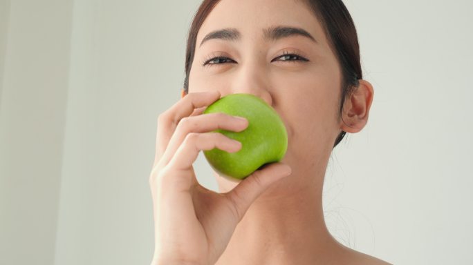 亚洲美女吃着青苹果