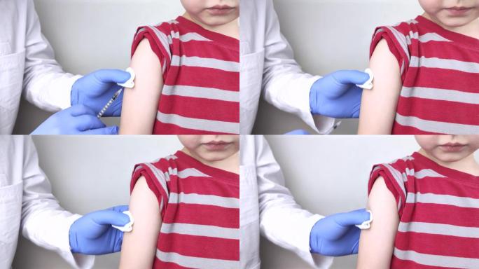 医生给男孩的肩膀注射疫苗