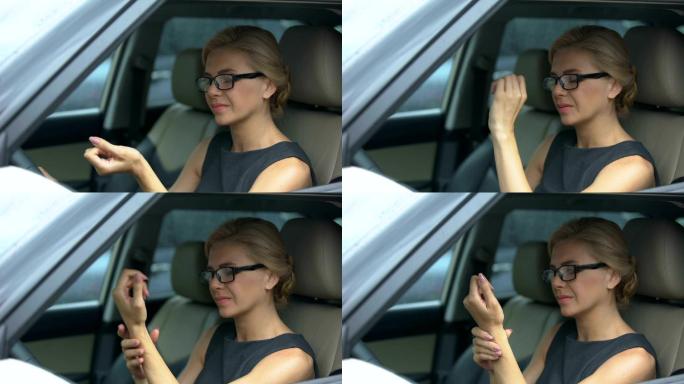美女戴眼镜坐在车里，手腕疼痛