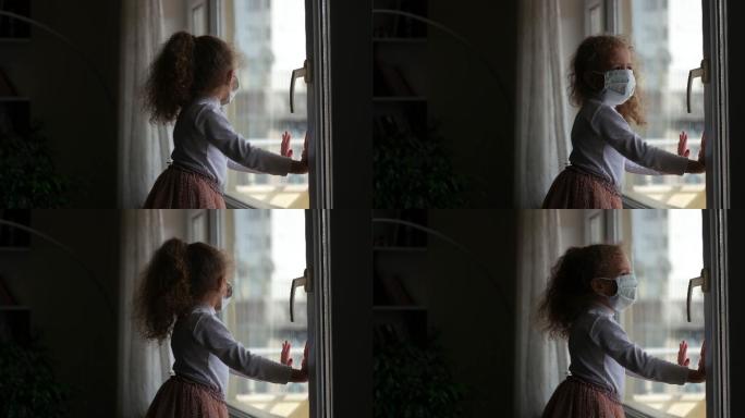 戴口罩的小女孩看着窗外